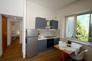 a kitchen with a table and a refrigerator and a table and chairs at Casa Parisina in Chianciano Terme