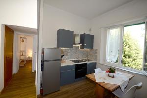 a kitchen with a table and a refrigerator and a table and a dining room at Casa Parisina in Chianciano Terme +3 photos