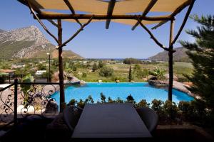 Blick auf einen Pool mit einem Tisch in der Unterkunft Adrasan Kayaköy Villaları in Kumluca