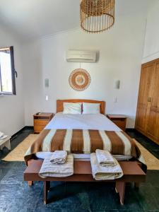 a bedroom with a large bed with two towels on it at Monte da Pechincha - Casa de Hóspedes & Spa in Estremoz