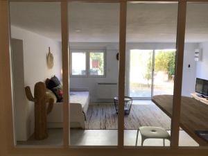 a room with a bed and a living room with a window at Appartement avec jardin in Perpignan