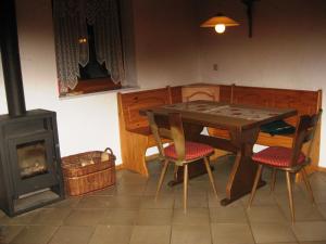 een eetkamer met een tafel en een houtkachel bij Ferienhof Beimler in Waldthurn