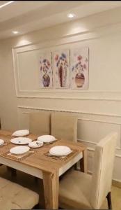 a dining room with a wooden table with plates on it at شقة فاخرة لعائلة بالمهندسين in Cairo