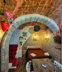 a bedroom with a bed in a stone wall at Suite Borgo 74 in Piana degli Albanesi