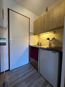 eine Küche mit einem weißen Kühlschrank und einer Arbeitsplatte in der Unterkunft Studio au cœur du Praz-de-Lys - Les Pralyssimes in Le Praz de Lys