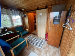 a room with a door and chairs and a table at Narikka Cottage, Cozy Stay in Central Kittilä, Near Levi Ski Resort in Kittilä +6 photos