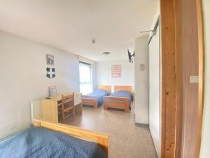 una camera con una camera da letto, un letto e una scrivania di Auberge le bois du cornet a La Forclaz