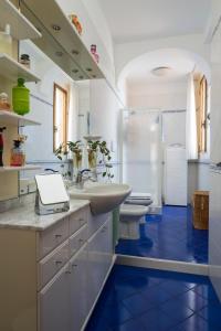 Un baño con suelo azul y lavabo e inodoro. en Skyview Paradise House, en Amalfi