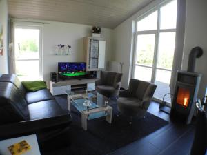 een woonkamer met een bank, stoelen en een televisie bij Haus Stressfrei - Nordhorn in Nordhorn +20 foto's