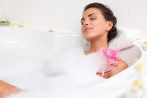 een vrouw die in een bad ligt met een bloem bij Haus Stressfrei - Nordhorn in Nordhorn