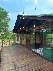 a pavilion with a wooden deck with glass walls at Casa do Lago em Alter do Chão in Alter do Chao
