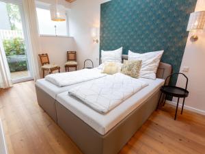 a bedroom with a large bed with a green wall at Ejas Haus am Meer in Lubmin +18 photos