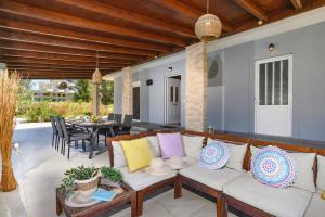 a living room with a couch on a patio at Villa Kalathos by Villa Plus in Kalathos