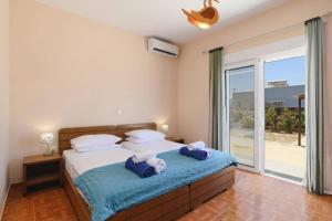 a bedroom with a bed with two towels on it at Villa Kalathos by Villa Plus in Kalathos +16 photos