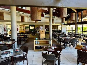 an empty restaurant with tables and chairs and tablesktop at Piscina, Mar e estilo em Angra dos Reis in Angra dos Reis