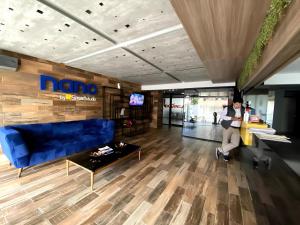 a man sitting in a living room with a blue couch at ¡ACOGEDOR DEPTO. DE 2 DORMITORIOS CON PISCINA! in Santa Cruz de la Sierra +23 photos