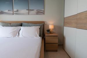 a bedroom with a bed with white sheets and a nightstand at Prieston Residences in Kilkis