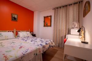 a bedroom with a bed and an orange wall at Mirador 2 del Mercado Central - habitacion con baño privado en el centro de la Ciudad Vella in Valencia
