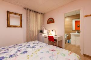 a bedroom with a bed and a desk and a microwave at Mirador 2 del Mercado Central - habitacion con baño privado en el centro de la Ciudad Vella in Valencia
