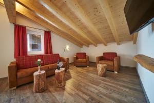 salon z kanapami i drewnianą podłogą w obiekcie Appartements Liebe Heimat w Saalbach Hinterglemm