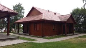 a small wooden house with a roof on a yard at Kemping Nad Drzewiczką in Drzewica