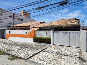a white house with a gate and a driveway at Da Silva residência à 200 metros da praia do Bessa in João Pessoa