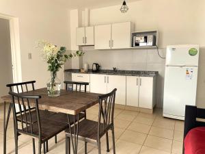 a kitchen with a table and chairs and a refrigerator at Médanos Negros Departamentos in San Juan +30 photos