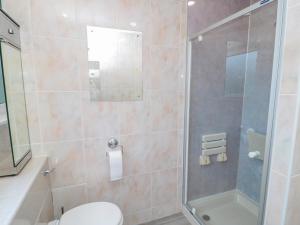 a bathroom with a shower with a toilet and a sink at Crosby Cottage in Wooler +28 photos
