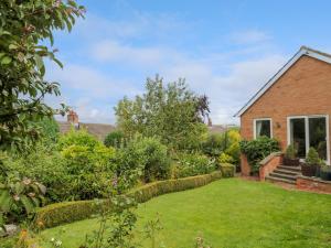 a garden in front of a brick house at Crosby Cottage in Wooler