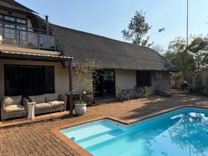 una casa con piscina delante de una casa en Rose Thatch Cottage, en Howick
