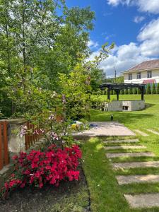 Un jardín con flores y un puente al fondo. en Guculka, en Yaremche