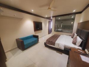 a bedroom with a bed and a couch in it at love kush hotel in Nagla Dhīmar