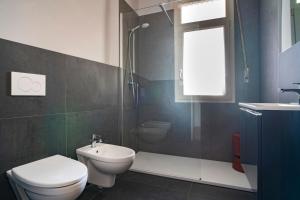 a bathroom with a toilet and a shower and a sink at Aosta Holiday Apartments - Promis in Aosta +15 photos