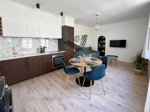 a kitchen with a table and chairs in a room at L'Escale d'Audry - Appartement sur cour situé en plein coeur de ville in Rochefort