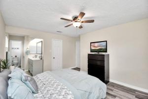 a bedroom with a bed and a ceiling fan at Coastal Comfort Moments from the Boardwalk with Gated Boat Parking in League City +22 photos