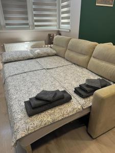 a couch with two towels sitting on a bed at West Park Apartment in Sofia +29 photos