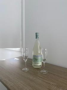Una botella de vino y dos copas de vino en una mesa en Casa Augusta 6, en Braga