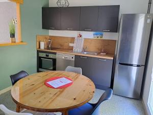 a kitchen with a wooden table and a refrigerator at Maison au calme 3 chambres avec terrasse et jardin in Ouzouer-sur-Loire +9 photos