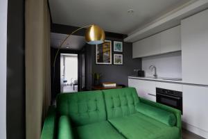 a living room with a green couch in a kitchen at The Gate London City in London