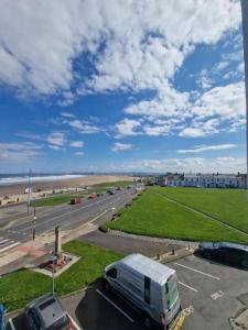 Un camión blanco circulando por una carretera junto a una playa. en The Green - Corner Plot Getaways, en Seaton Carew