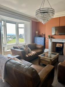 Una sala de estar con un sofá y una lámpara de araña. en The Green - Corner Plot Getaways, en Seaton Carew