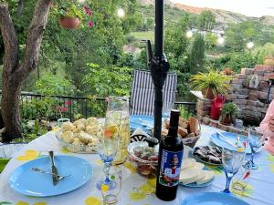 a table with a bottle of wine and plates of food at Guest house Me and grandfather-მე და პაპა in Dedoplis Tskaro
