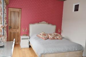 a bedroom with a bed and a pink wall at Chateau Roquehort in Monein