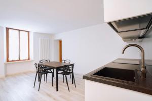 アオスタにあるAosta Holiday Apartments - Piazza Chanouxのキッチン(テーブル、椅子、シンク付) +16枚の写真
