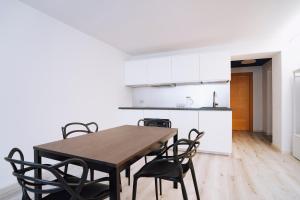 アオスタにあるAosta Holiday Apartments - Piazza Chanouxの木製のテーブルと椅子のあるキッチンとダイニングルーム
