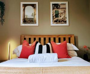 霍利Grassmere - 3 bed house with private garden的卧室里有一张床，上面有红色和白色的枕头