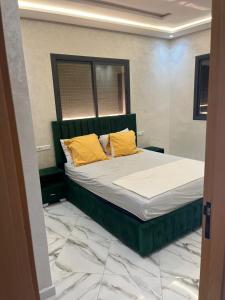 a bedroom with a bed with yellow pillows on it at Appartement Martil neuf proche mer in Martil