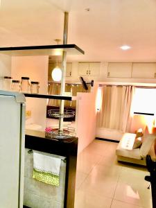 a living room with a couch and a kitchen at Flat perfeito no coração de Boa Viagem in Recife