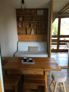 La Plagne Bellecôte في بلاني بيليكوت: غرفة معيشة مع طاولة خشبية وأريكة