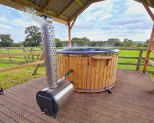 a hot tub and a smoker on a deck at Reindeer Lodge Very Special Retreat With Private Hot Tub Near Cannock Chase By StayStaycations in Colton